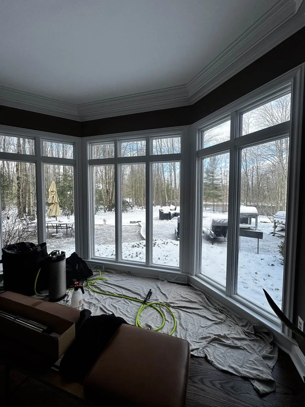 Dark-stained A-frame home with a full glass gable wall treated with solar window film in Northeast Ohio