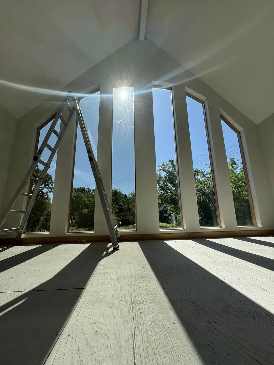 Sunlight pouring through tall cathedral windows in a Northeast Ohio home after film installation