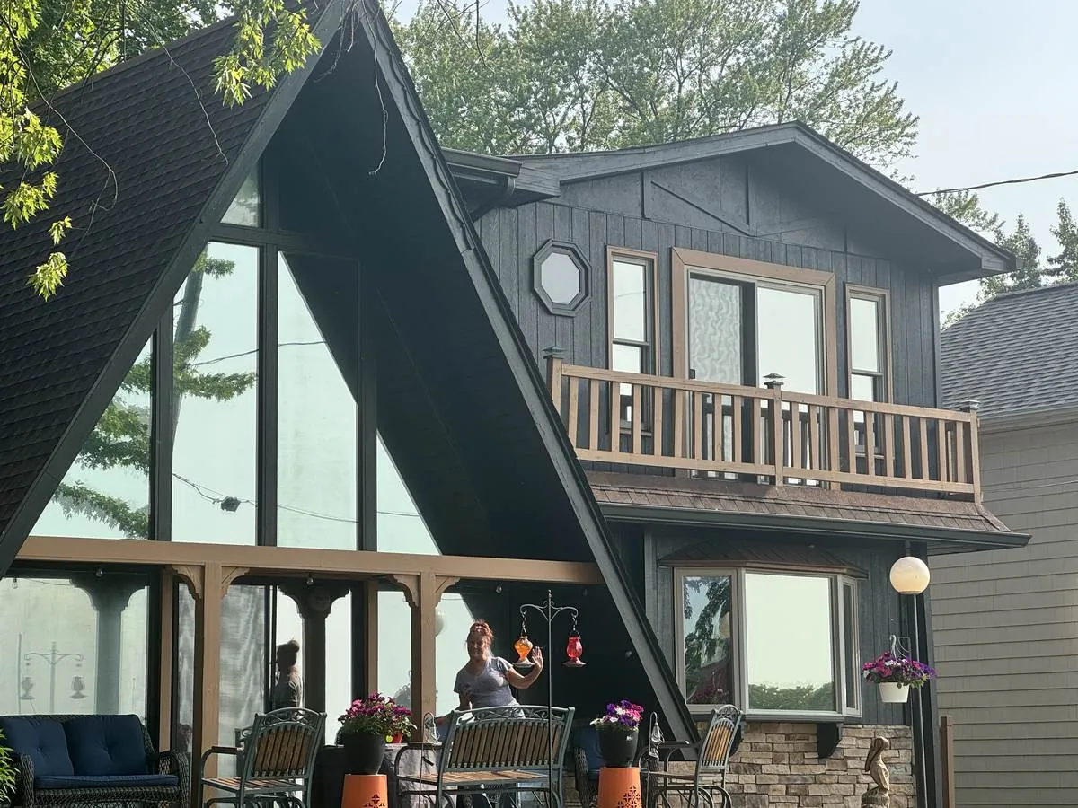 Lakefront A-frame home with a full glass gable wall treated with window film